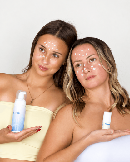 Dve dekleti s točkovno naneseno Aizen cinkovo pasto na obrazu držita izdelka iz paketa ClearSkin system